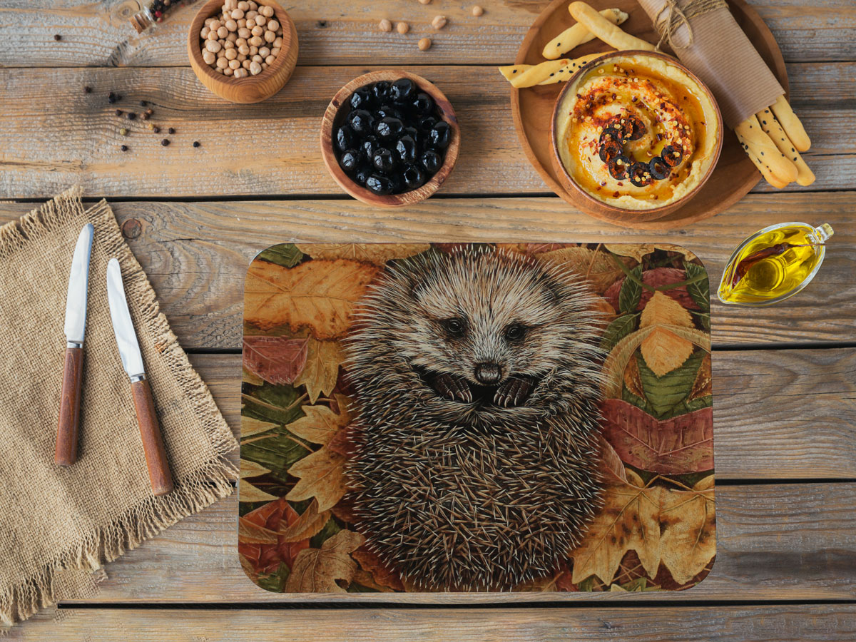 glass chopping board with picture of hedgehog on itsurrounded by bowls of olives and dips