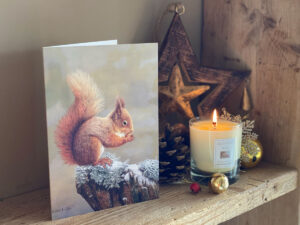 christmas card on shelf with candle