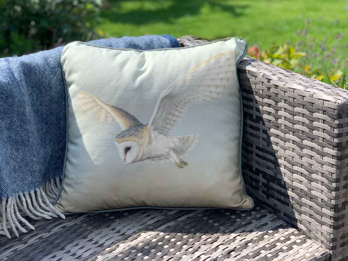 owl cushion featuring painting of barn owl in flight on garden furniture