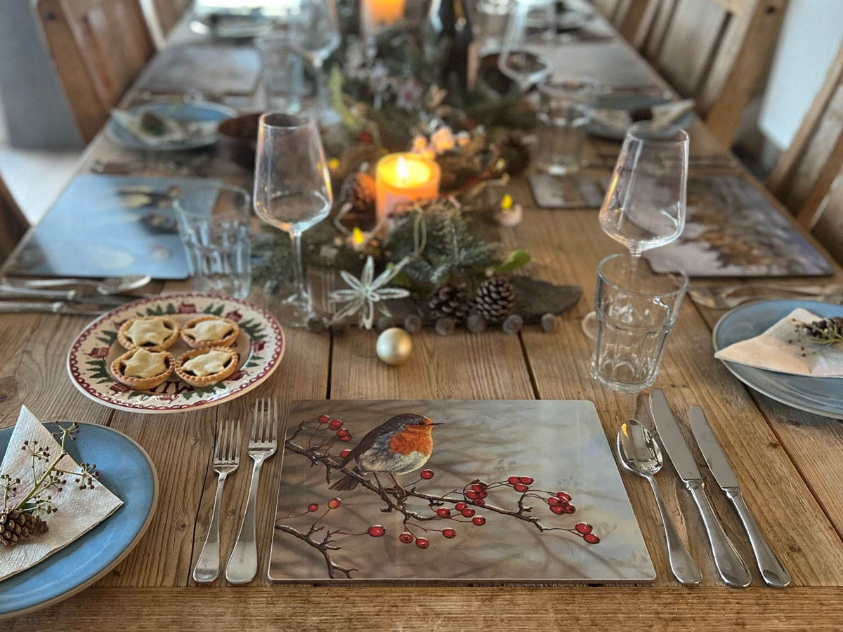 table set for dinner with placemat featuring a robin in foreground
