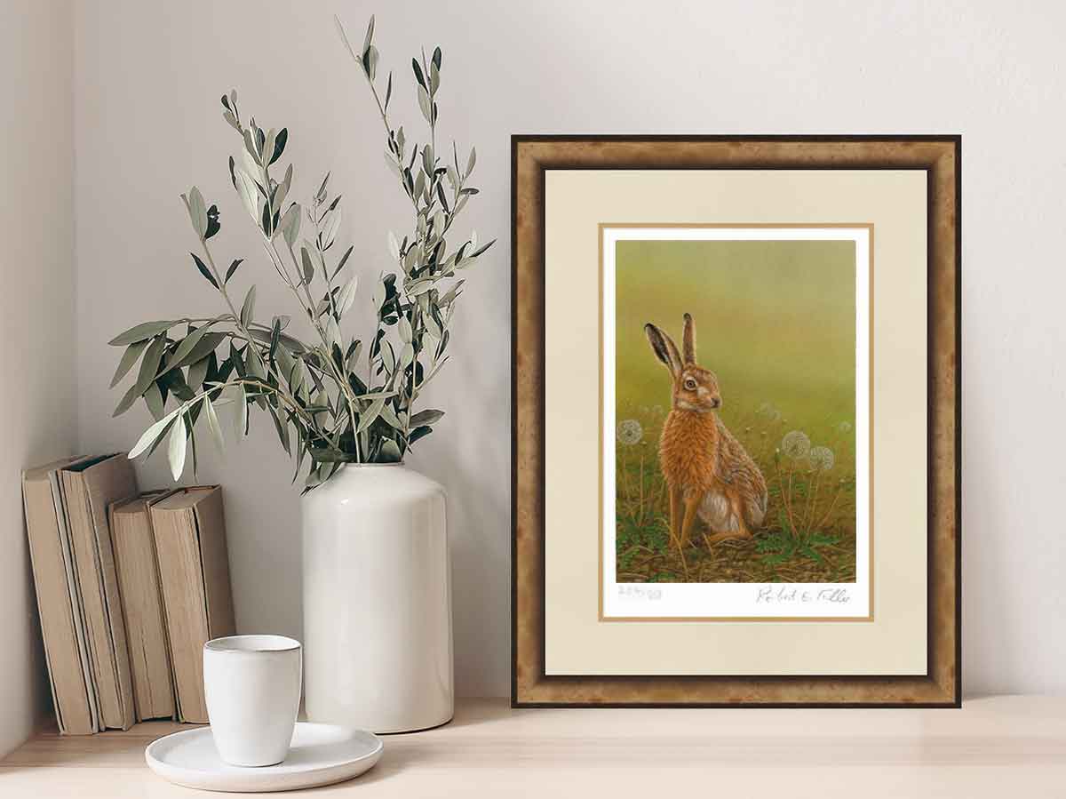 framed painting of hare with vase of leaves and coffee cup on book shelf