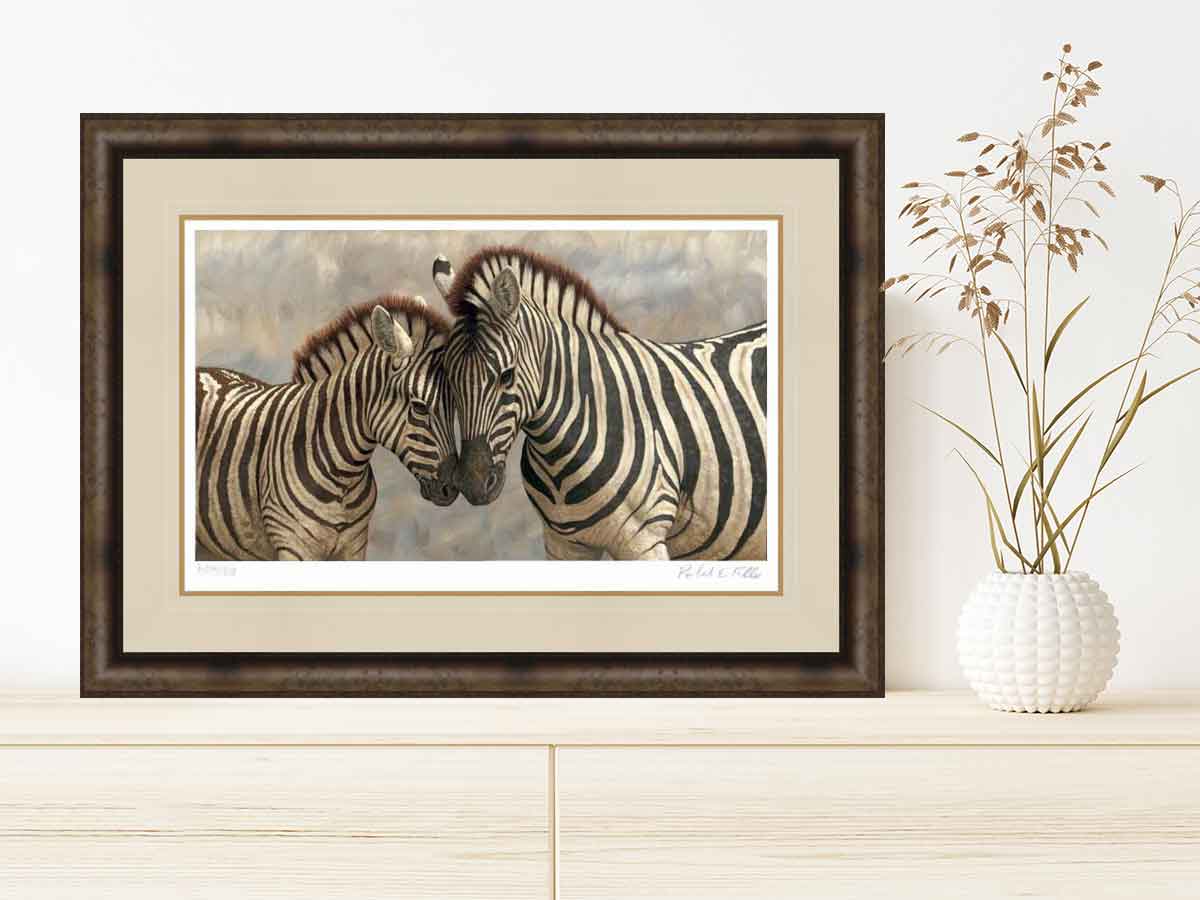 framed picture of zebras touching noses on sideboard wtih vase of dried flowers