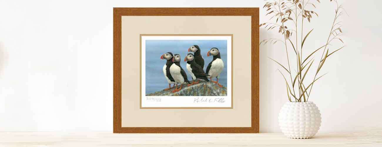 framed print of puffin painting with white vase and dried flowers