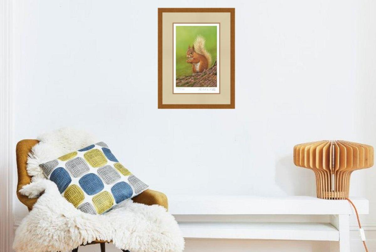 framed art print featuring red squirrel upright above chair