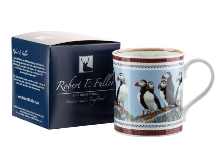 A coffee cup with gift box. llustration of a group of puffins standing on a rock by nature artist Robert E Fuller